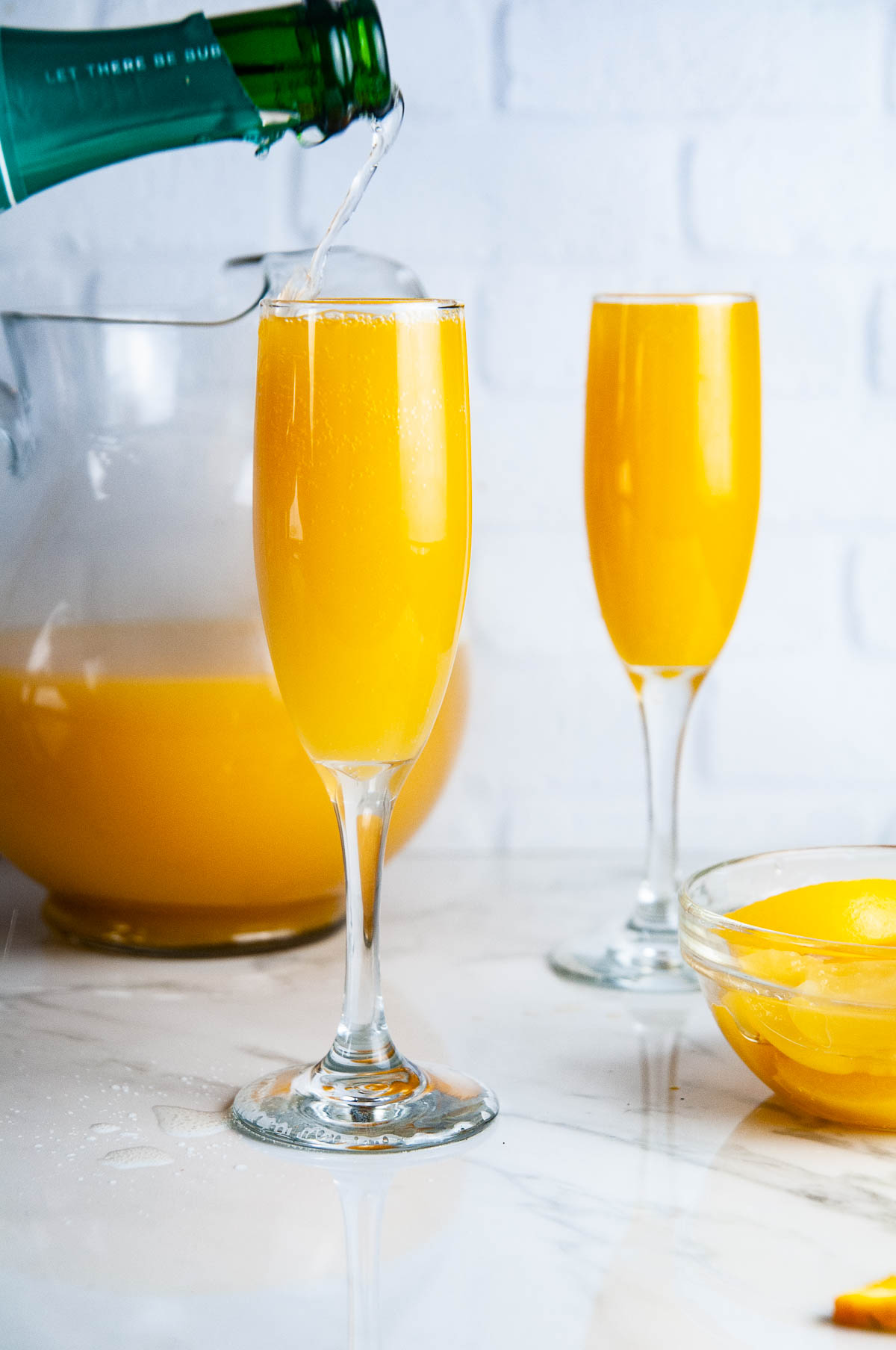 Fill up champagne glasses about halfway with the juice mixture. Then top it off with champagne and peach schnapps.