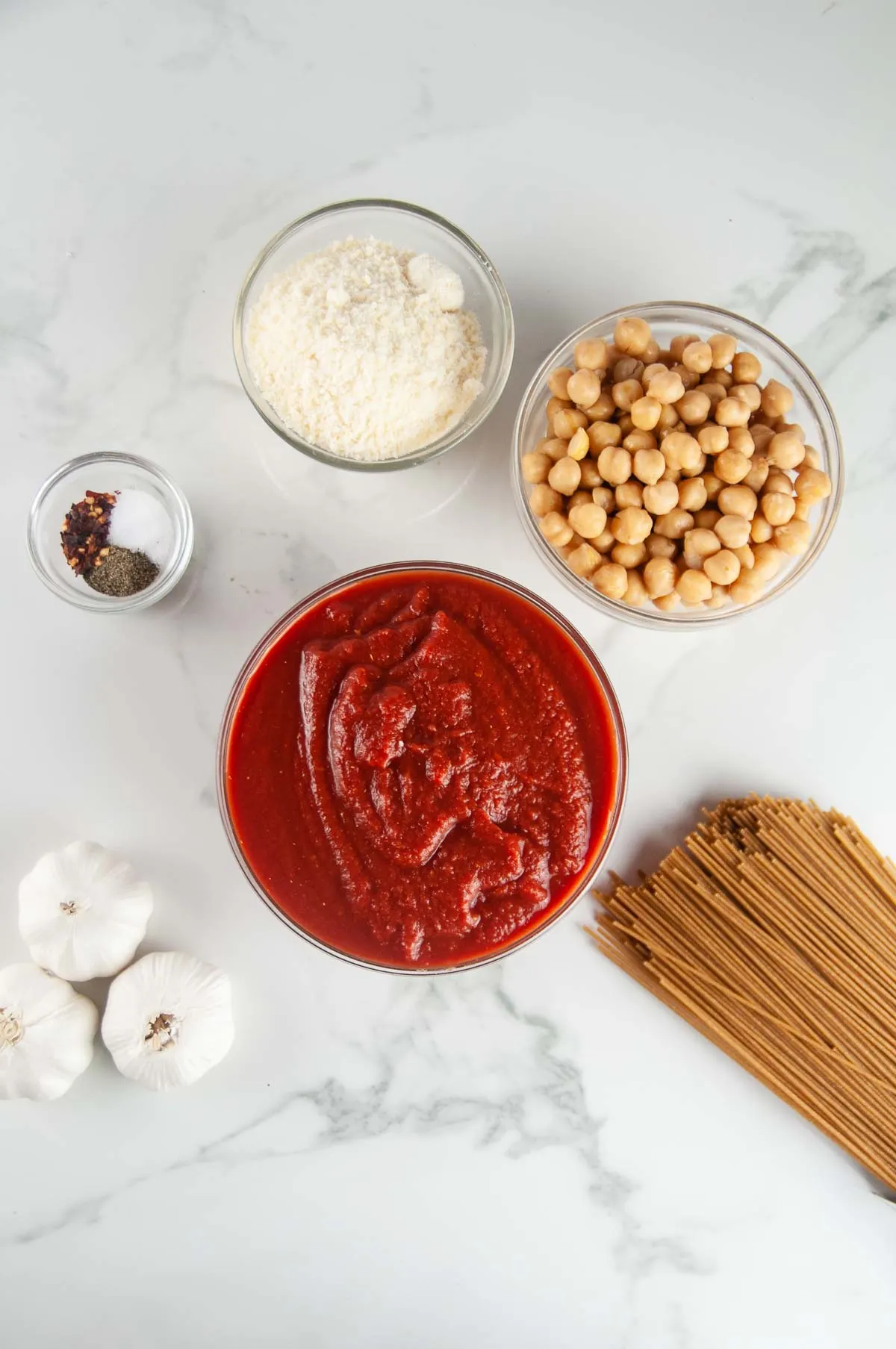 Ingredients for Easy Pasta with Chickpeas or Pasta e Ceci: Pasta, Crushed Tomatoes, Garlic, Spices, Parmesan Cheese, and Chickpeas