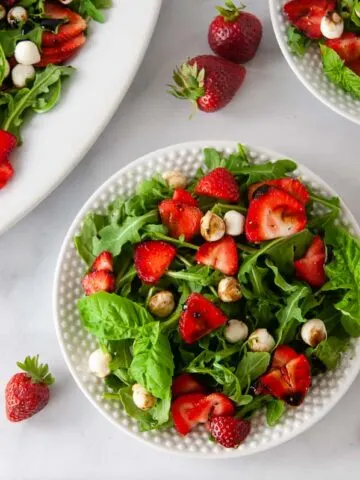 Strawberry Caprese salad is a classic summer meal. This light dish bursts with the sweetness of the fresh berries and basil, spicy arugula and creamy bites of mozzarella. A sweet balsamic drizzles coats adds the finishing touch.