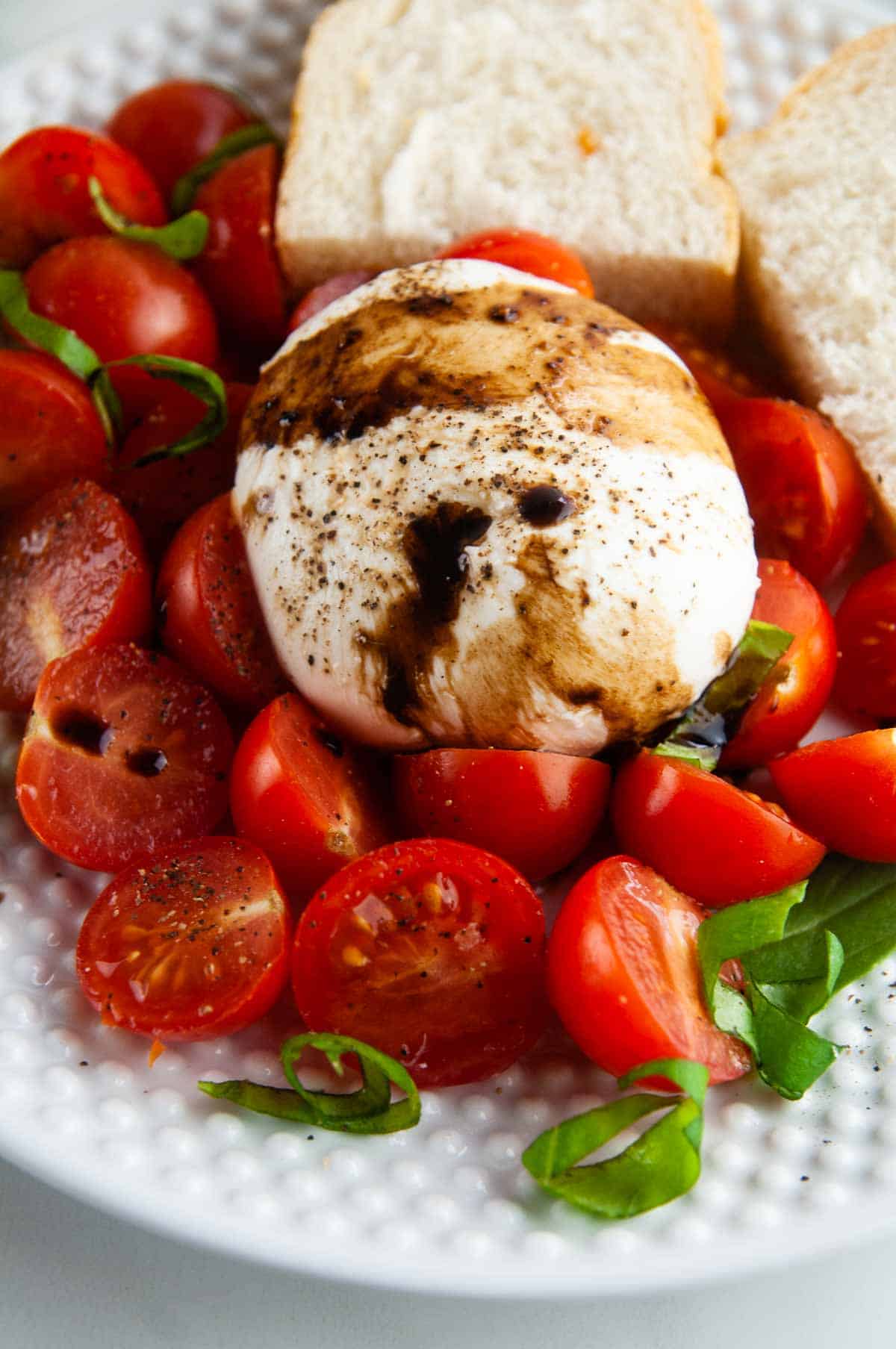 Burrata caprese salad takes the classic flavors of the tomato, mozzarella, and basil combination and turns it up a notch with decadent burrata cheese. This easy variation of caprese with burrata makes for an effortlessly elegant dinner or appetizer anytime.