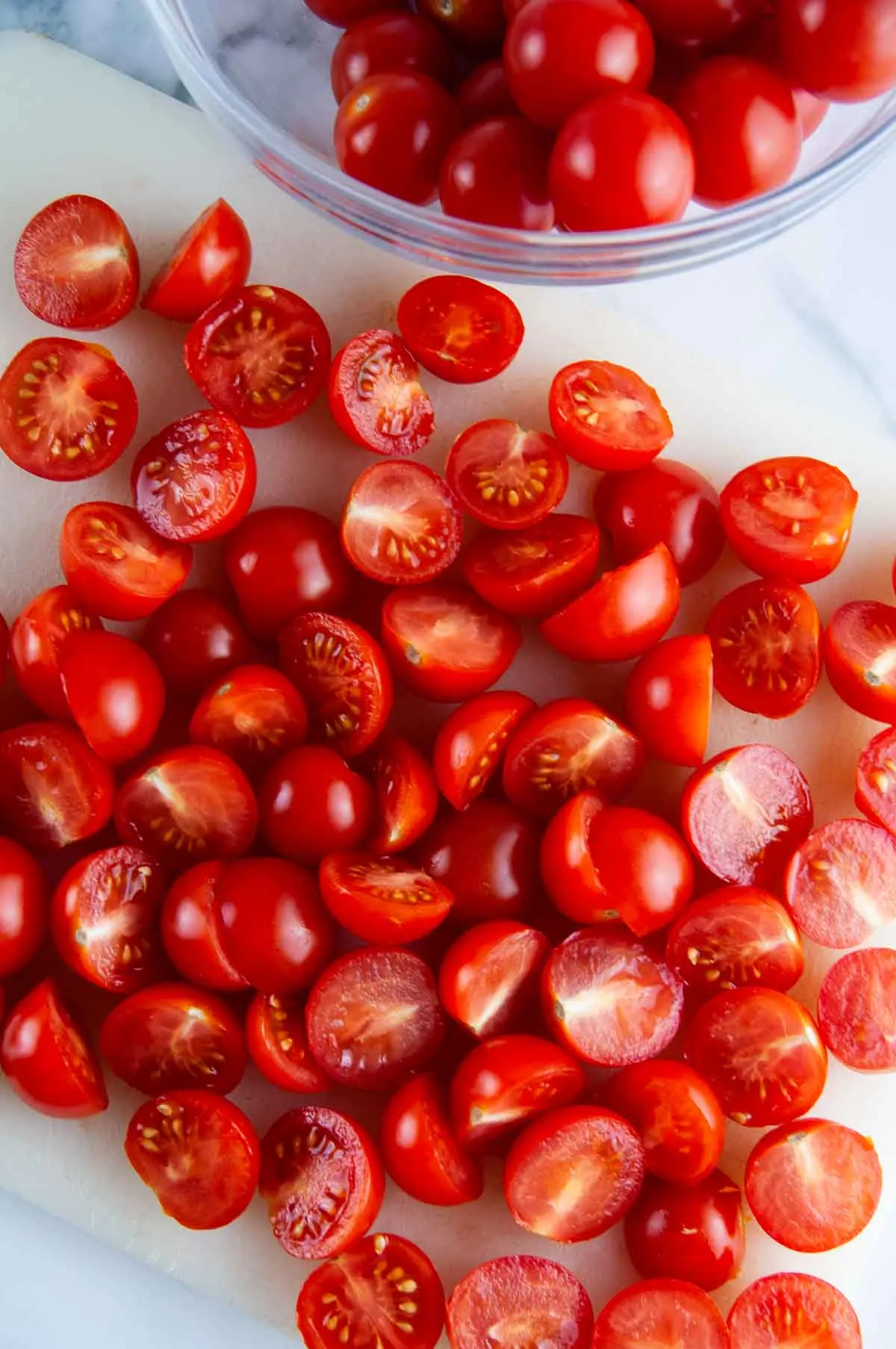 Cut the cherry tomatoes in half for burrata caprese salad.