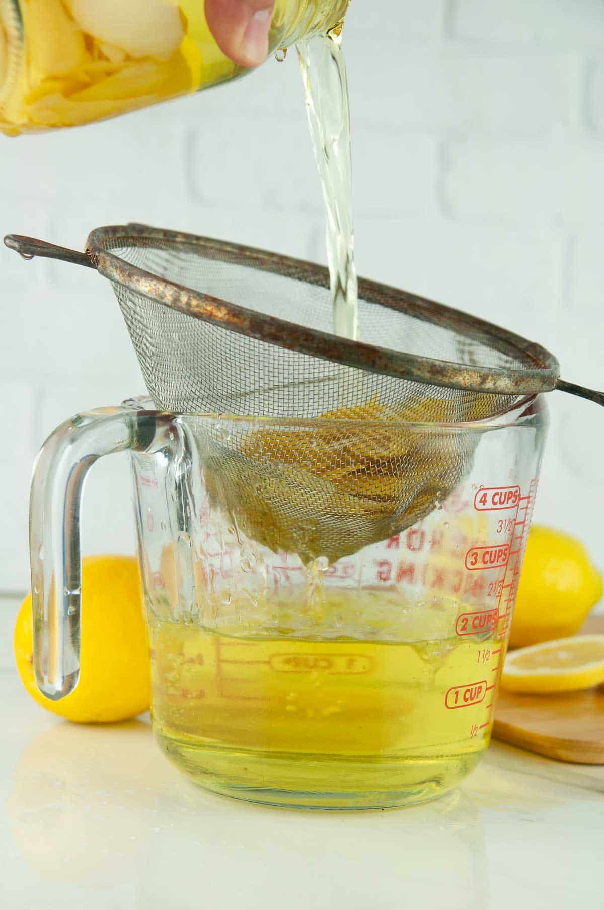 Strain the lemon peels out of the liqueur.
