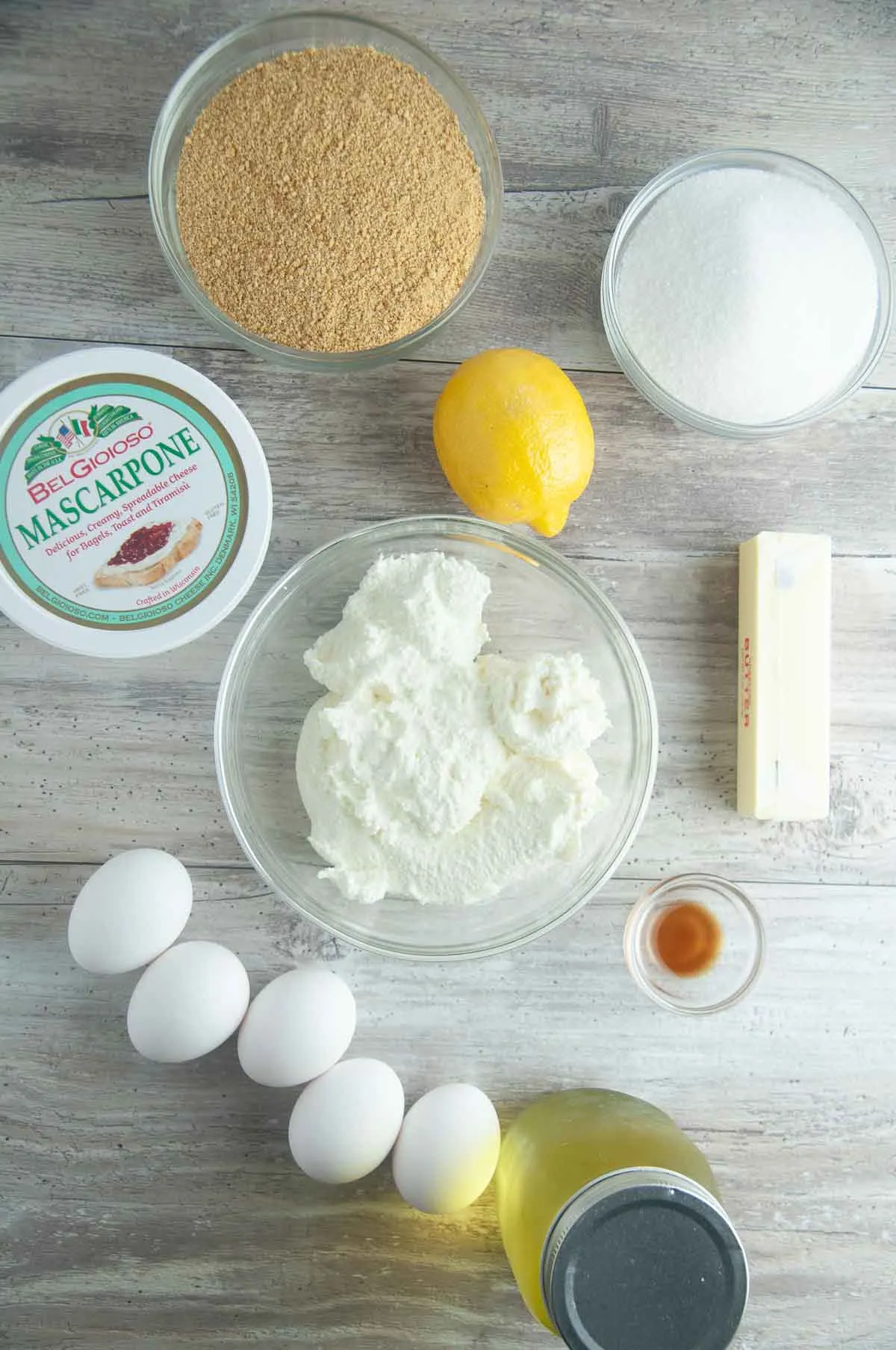 Ingredients for Limoncello Cheesecake: Graham Cracker Crumbs, Sugar, Mascarpone Cheese, Ricotta Cheese, Butter, Vanilla, Eggs, Limoncollo, and Lemon Zest