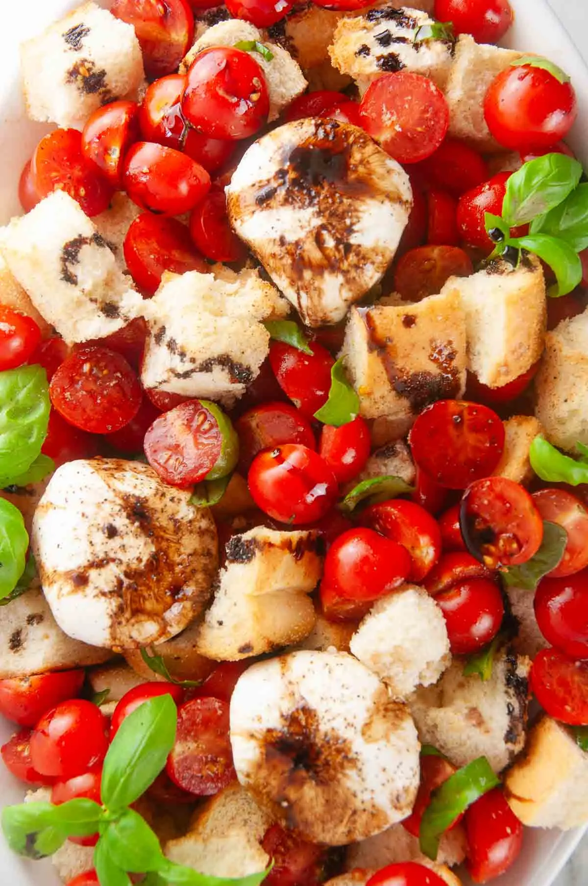 Burrata panzanella salad is the best kind of salad! This rustic salad is one made solely of creamy burrata, toasted pieces of Italian bread, bright tomatoes, and slathered in tangy, sweet balsamic.