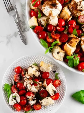 Burrata panzanella salad is the best kind of salad! This rustic salad is one made solely of creamy burrata, toasted pieces of Italian bread, bright tomatoes, and slathered in tangy, sweet balsamic.