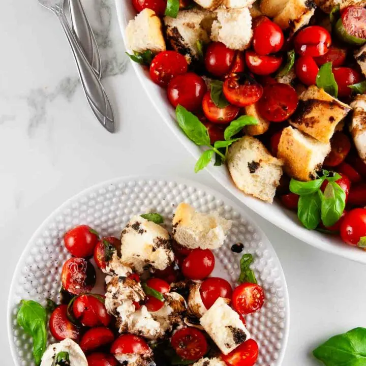 Burrata panzanella salad is the best kind of salad! This rustic salad is one made solely of creamy burrata, toasted pieces of Italian bread, bright tomatoes, and slathered in tangy, sweet balsamic.