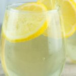 Limoncello spritzers in glasses with lemon slices and text reading limoncello prosecco spritz