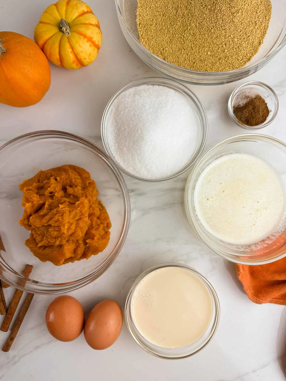 Ingredients for pumpkin pie with a graham cracker crust: graham cracker crumbs, sugar, spices, melted butter, pumpkin, evaporated milk, and eggs