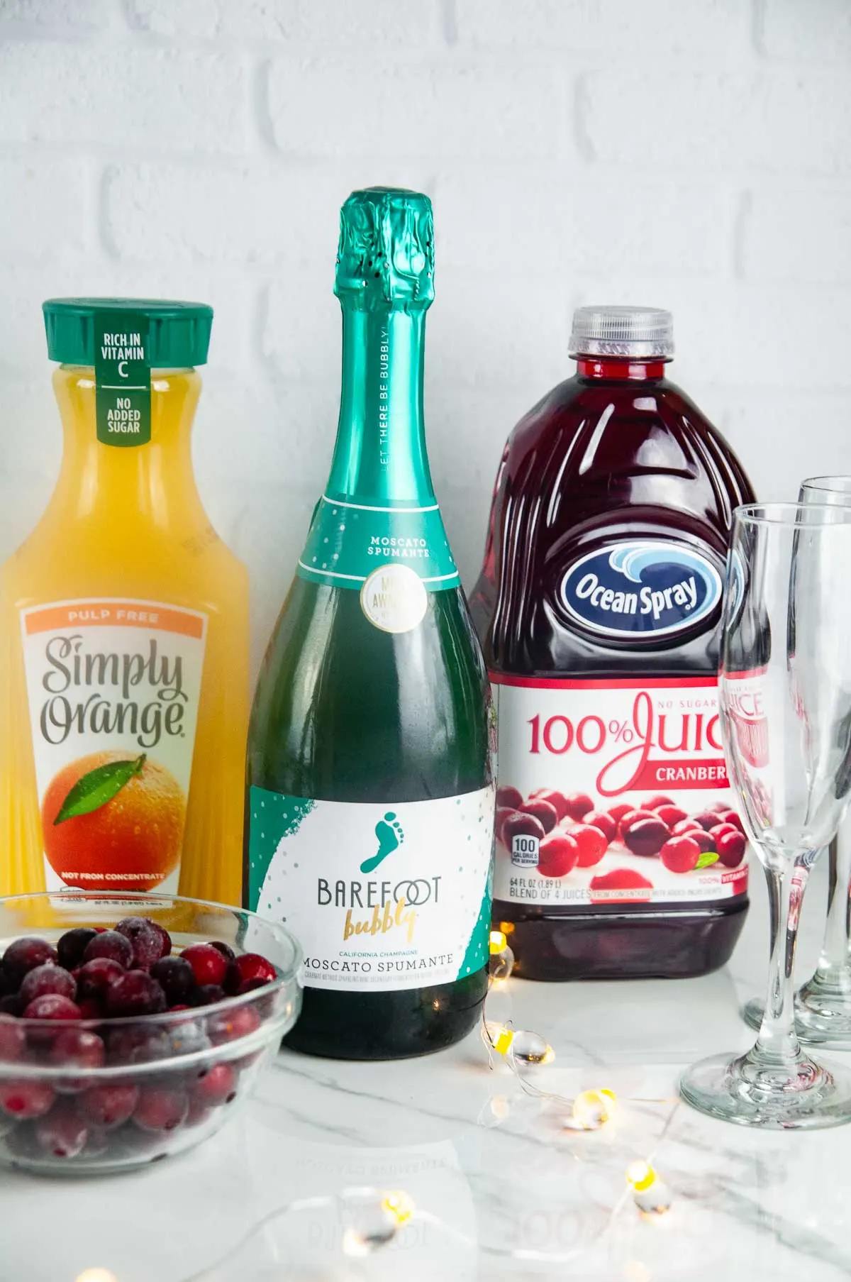 Ingredients for Christmas Morning Mimosas: Orange Juice, Cranberry Juice, and Sparkling Wine