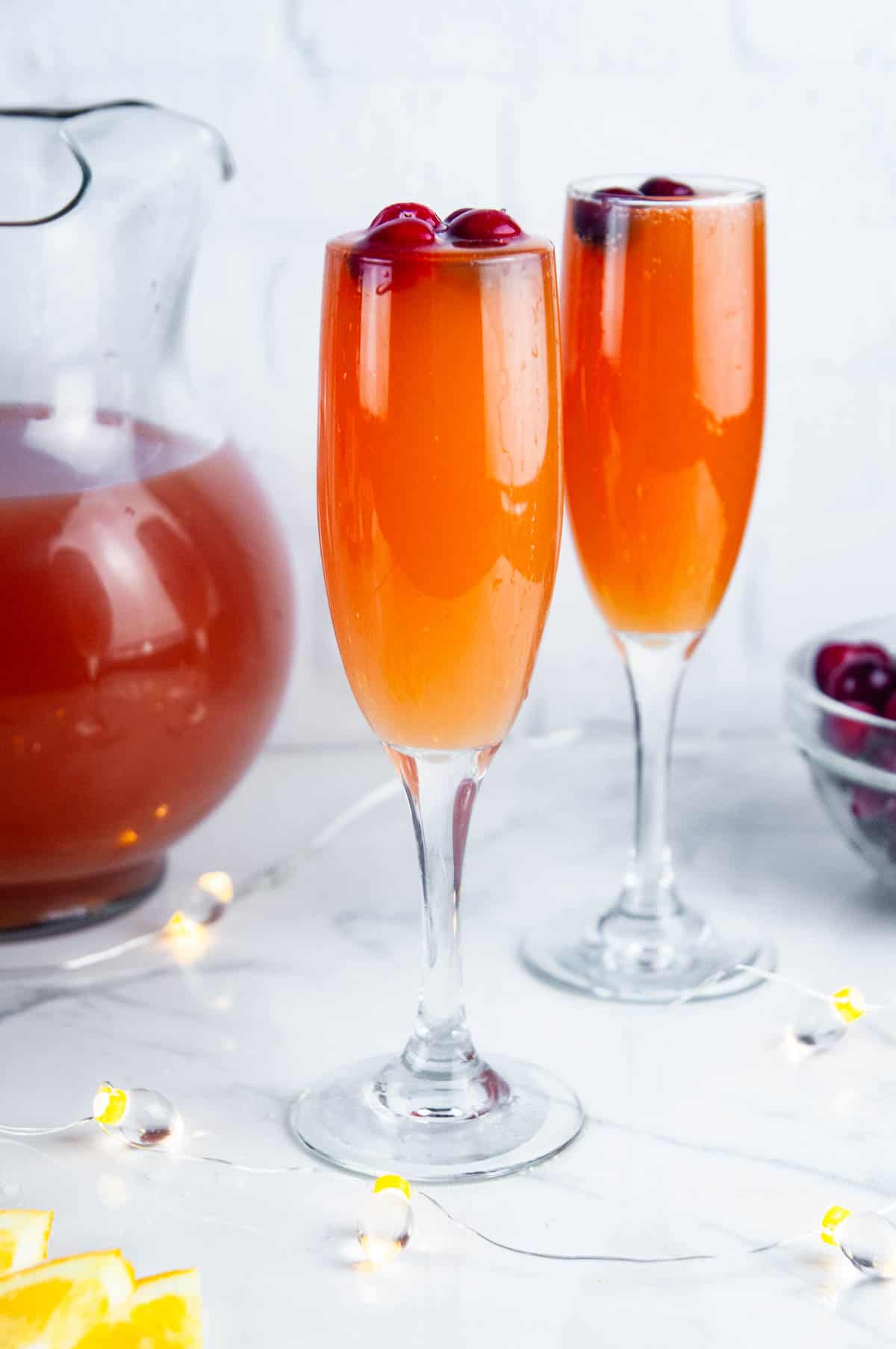 Christmas morning mimosas feature cranberry juice, orange juice and a generous pour of your favorite sparkling wine for a festive holiday mimosa.