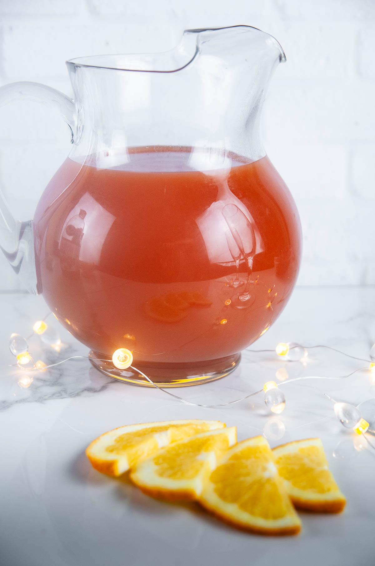 A pitcher of cranberry orange mimosas perfect for Christmas morning or any other holiday brunch occasion!