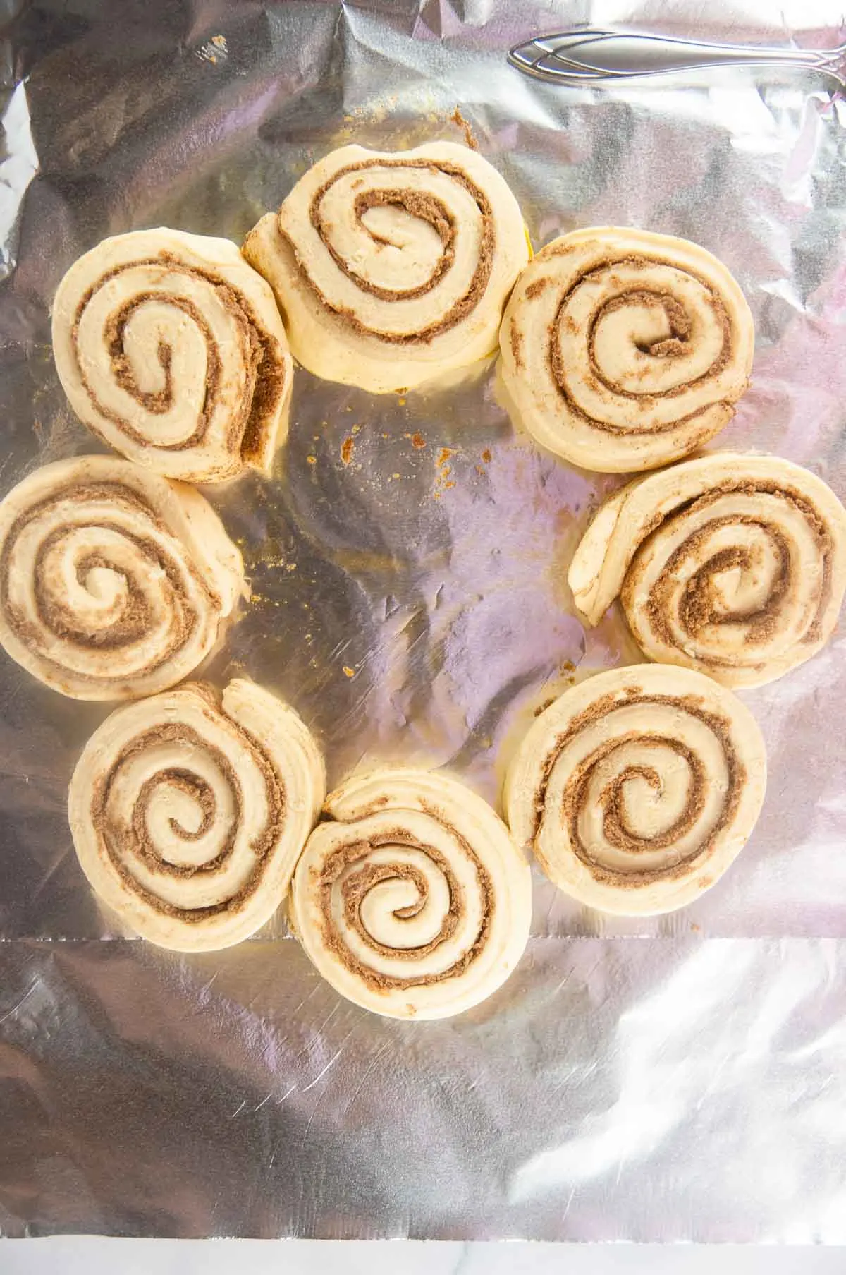Arrange the cinnamon rolls on a lined baking sheet so they make a hollow circle.