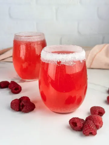 Sparkly raspberry champagne cocktails are a beautiful pink drink perfect for the holidays, Valentine's Day, date night in, or special spring and summer occasions. These raspberry cocktails feature sparkling wine, raspberry simple syrup and a shot of flavored vodka.