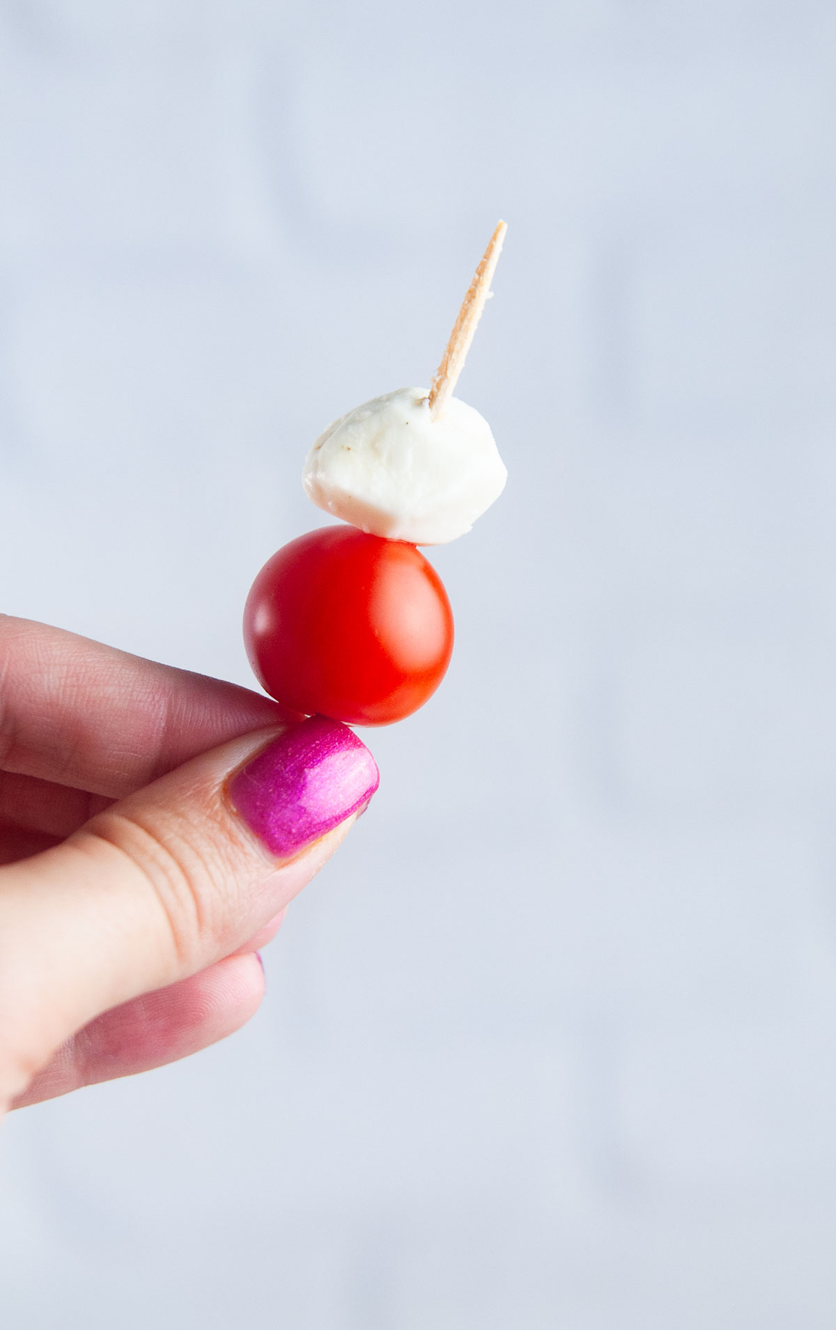 Spear a mini mozzarella ball onto the toothpick after the cherry tomato.