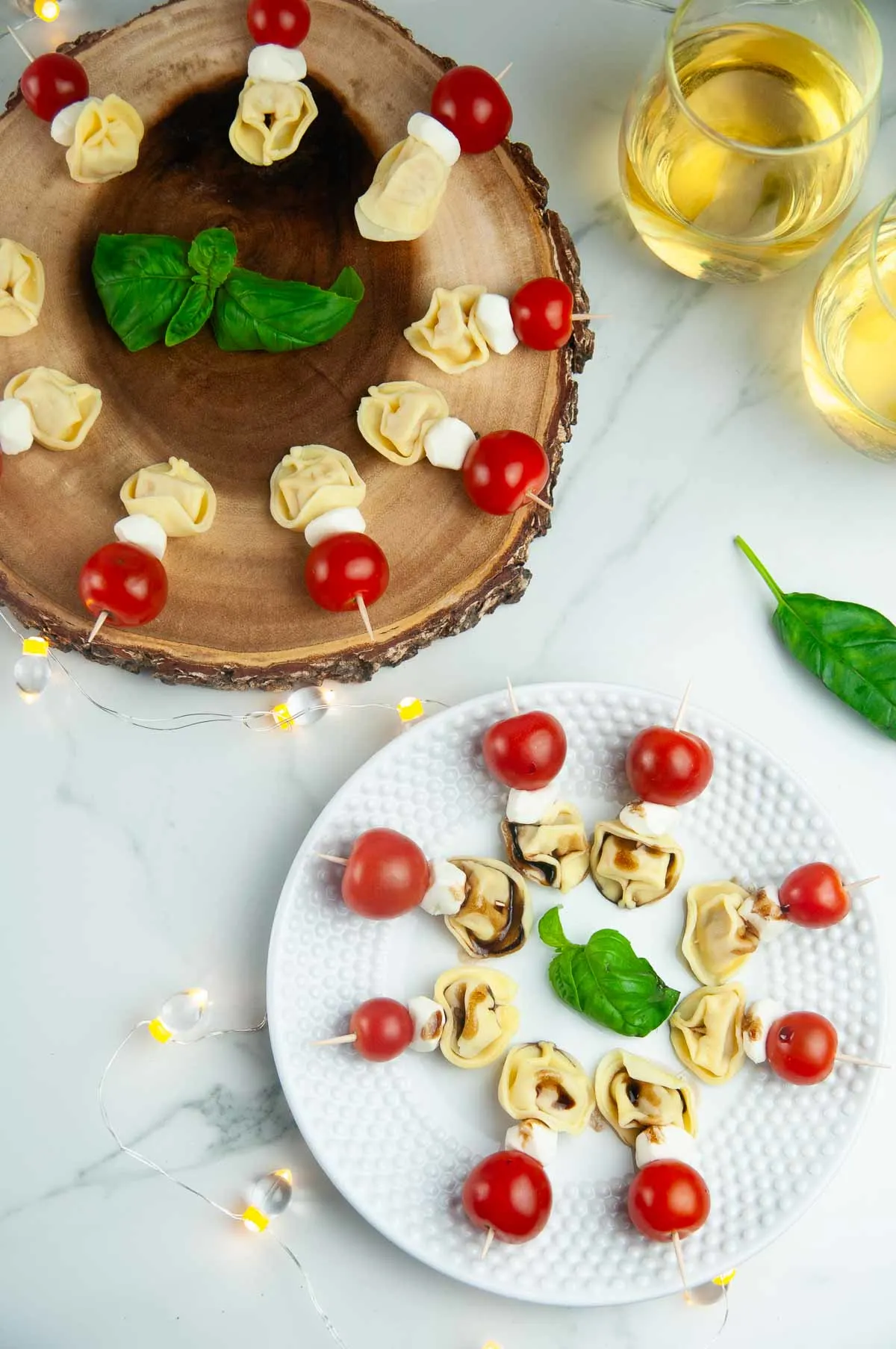 Two platters with Tortellini Caprese Skewers arranged on them for an appetizer party.