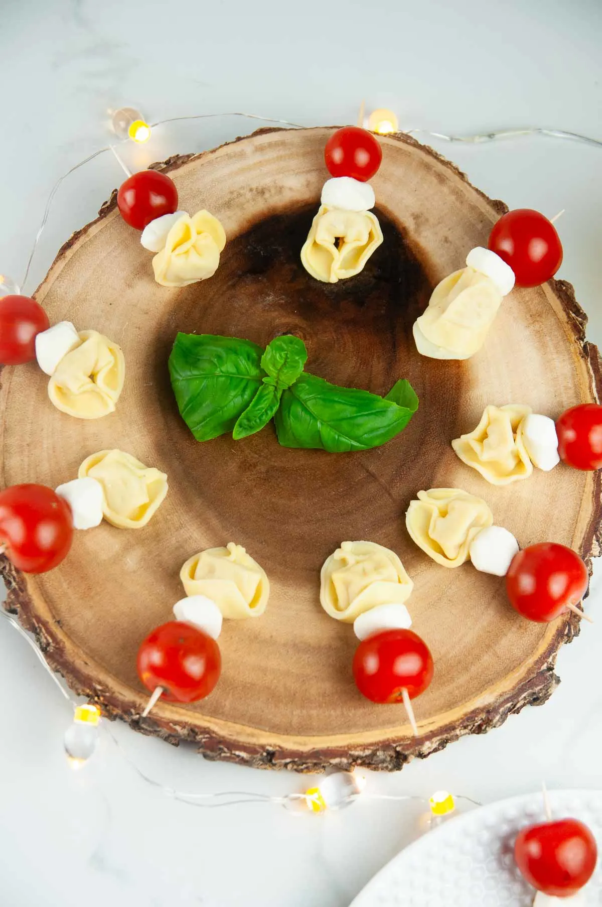 Tortellini Caprese Skewers arranged on a wooden platter without balsamic drizzle or pesto added.