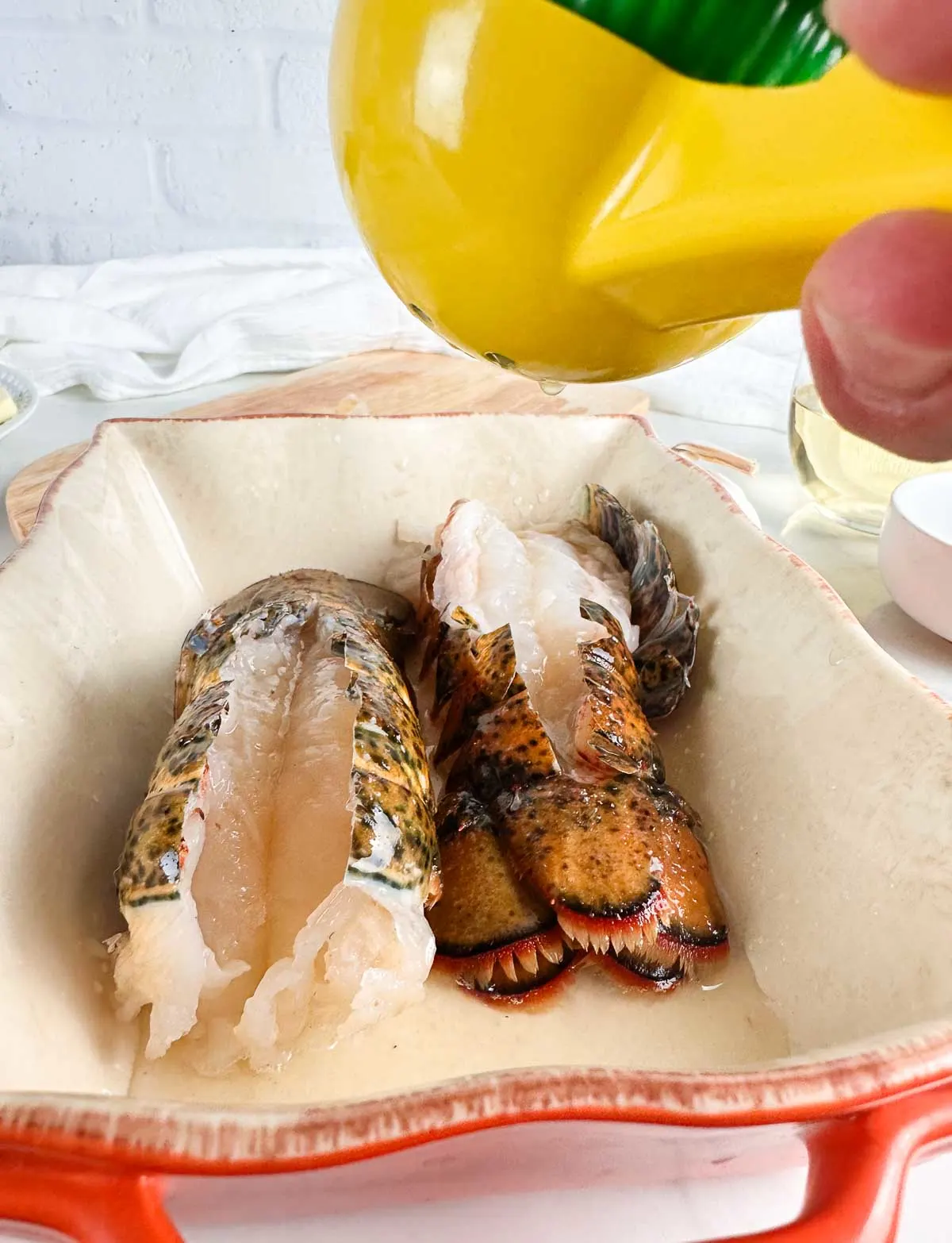 Squeeze fresh lemon over the butterflied lobster tails.