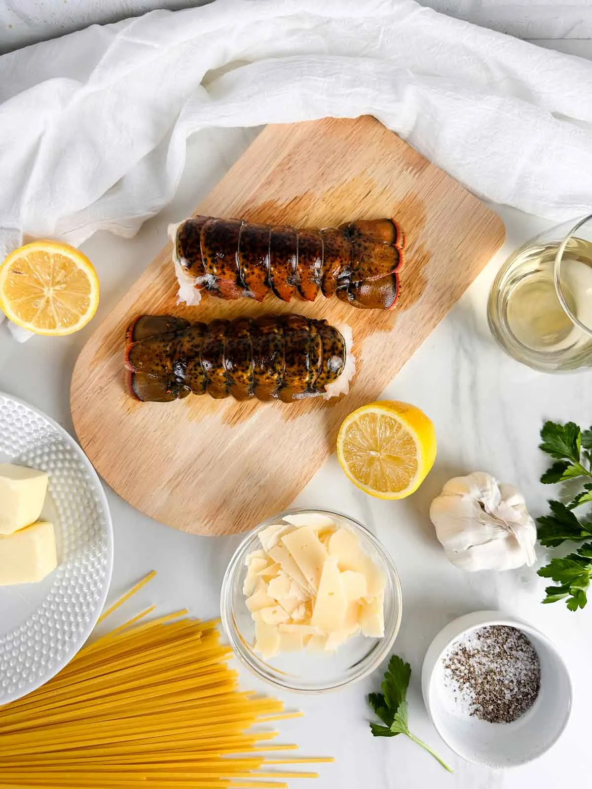 Ingredients for Lobster Scampi Linguine: Lobster Tails, White Wine, Garlic, Parmesan Cheese, Butter, Lemon, Salt and Pepper, and Linguine