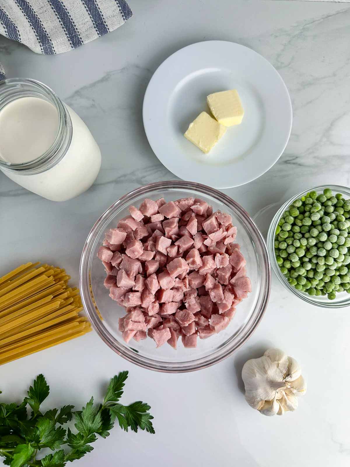 Ingredients for ham and pea pasta: pasta, heavy cream, Parmesan cheese, butter, garlic, ham, and peas