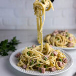 A plate of pasta with ham and peas makes delicious use of leftover ham in a hearty Italian inspired dinner.