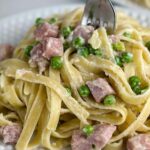 A photo of plate of pasta with ham and peas set into a decorative text box reading ham and pea pasta