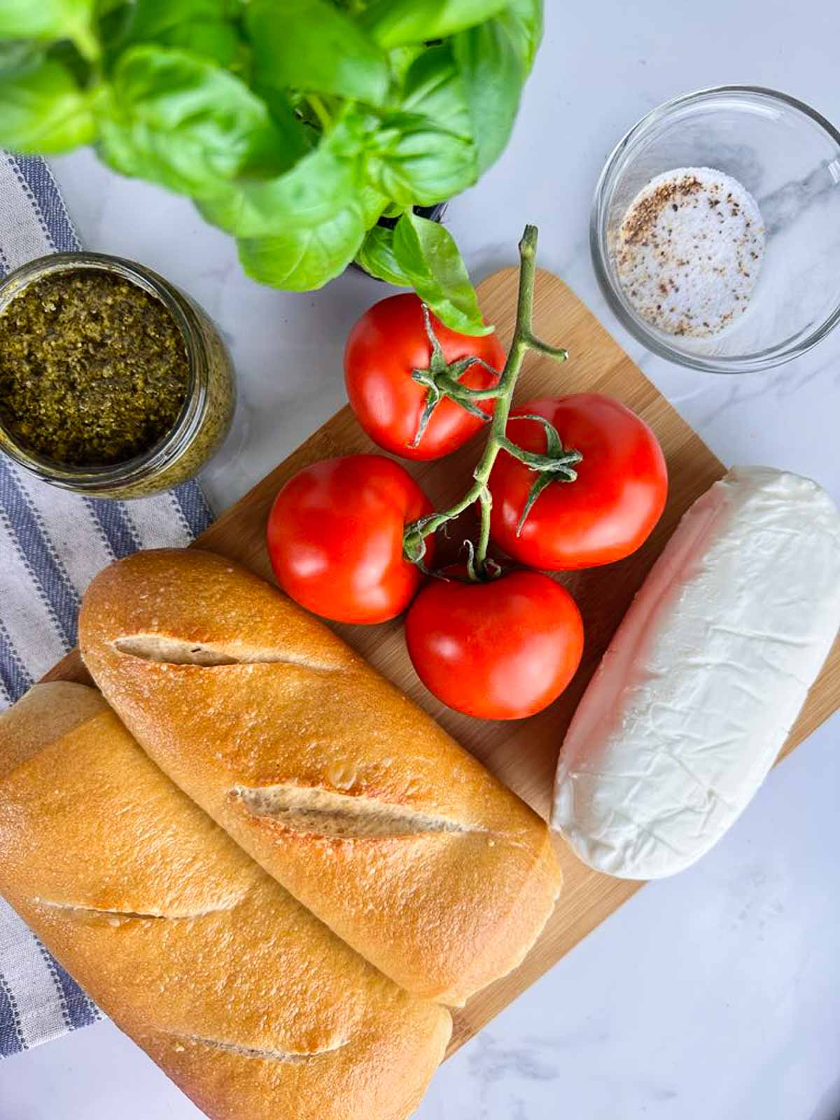 Ingredients for Baguette Caprese Sandwich with Pesto: Baguettes, Tomatoes, Pesto, Fresh Basil, Fresh Mozzarella, and Salt and Pepper