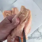 Slice the chicken breasts through the thickest part, leaving about 1/4 inch uncut.