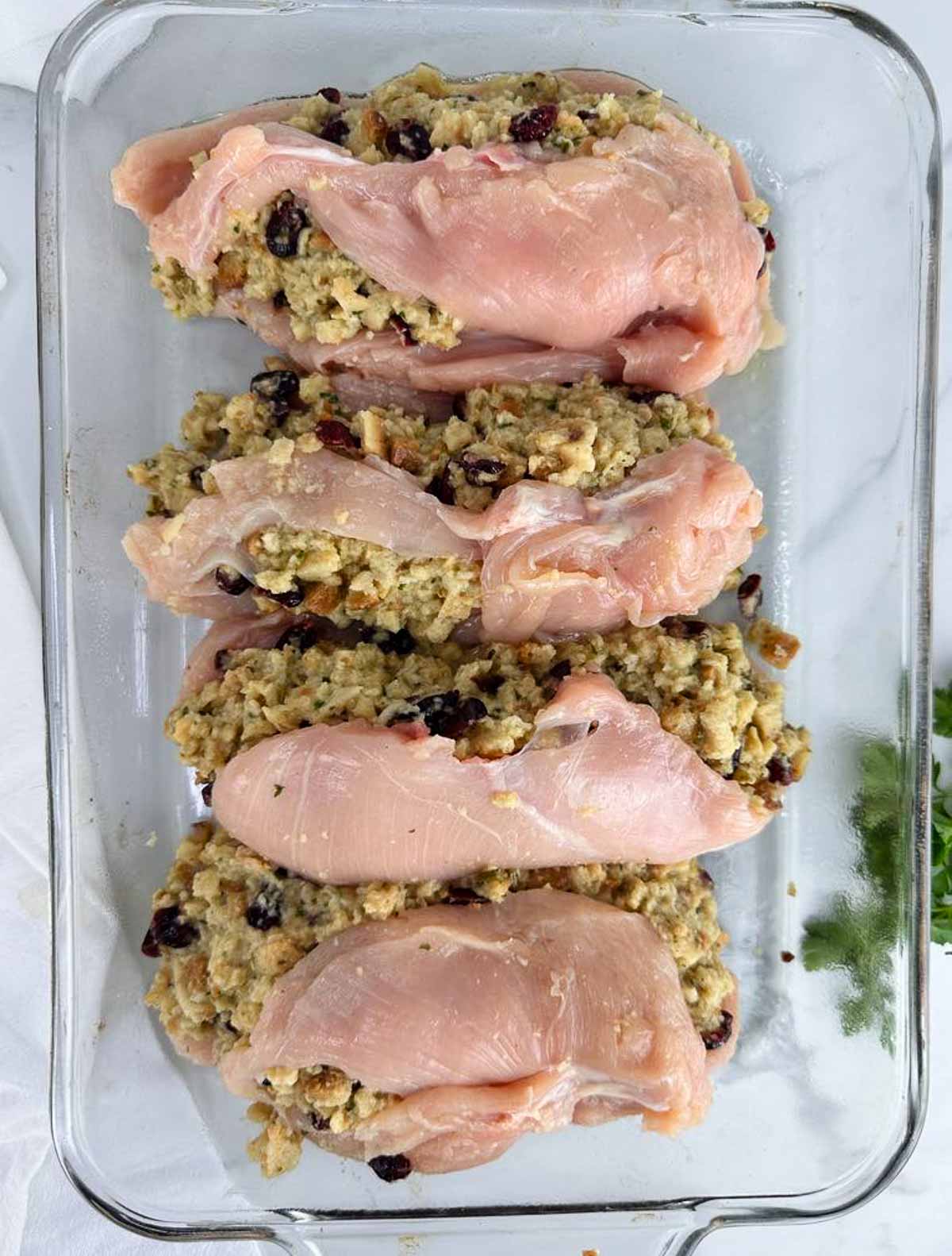 Stuff each chicken breast with one quarter of the stuffing and put the stuffed chicken breasts into a baking dish
